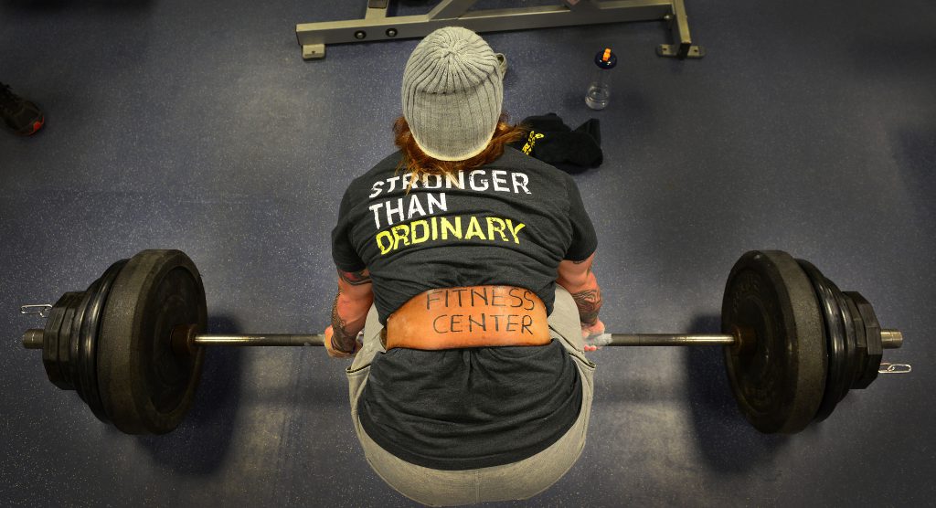 Power and Madam Pelosi 5 Woman lifting weights wearing t-shirt with words 'stronger than ordinary'